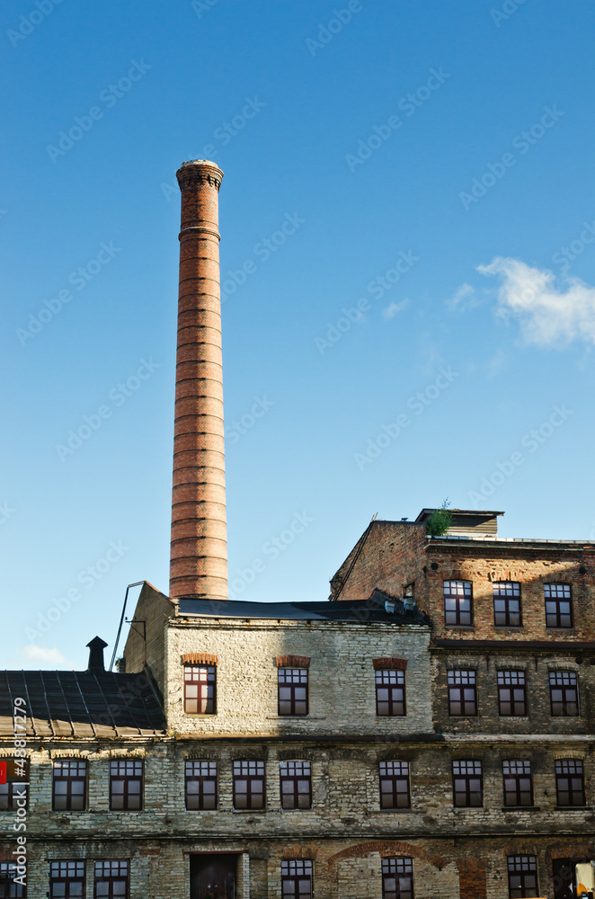 Smokestack towers over the old industrial building