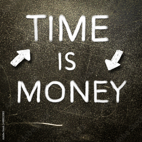 Time is money handwritten with white chalk on a dark background