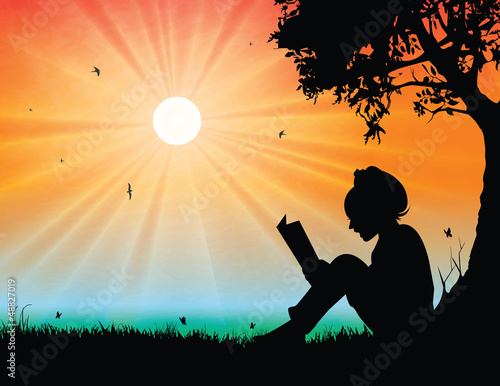 Young girl reading in sunset background