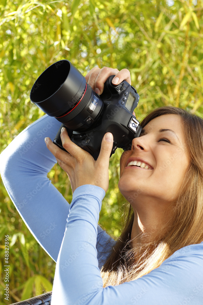 Junge Frau fotografiert mit einer teuren Spielreflexkamera Junge Frau fotografiert mit einer teuren Spielreflexkamera