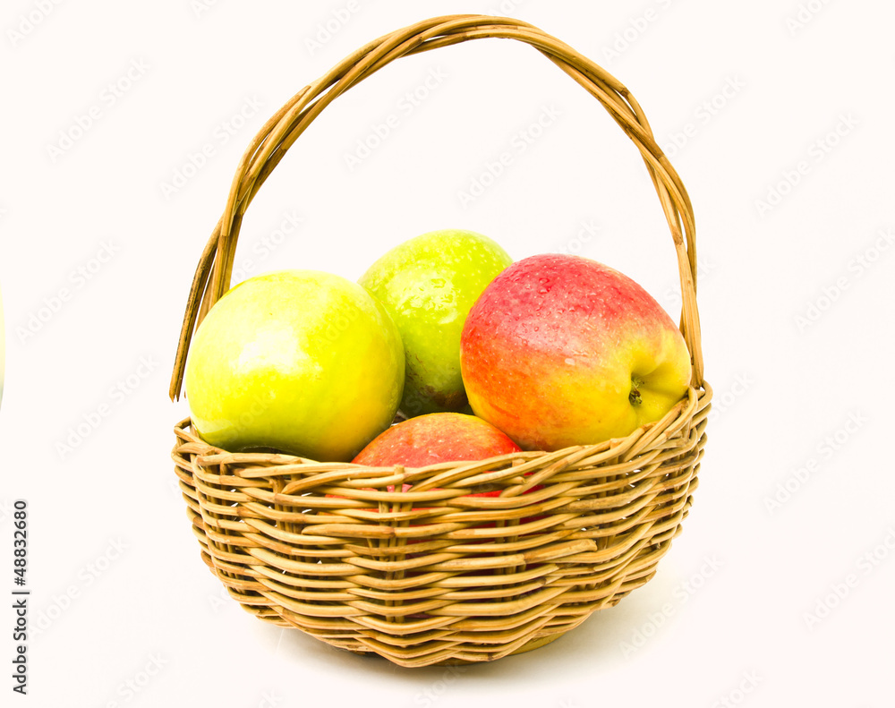 Green and red apples in a basket isolated on white background