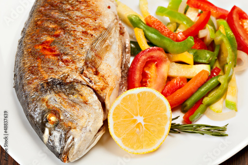 Grilled dorado fish with lemon and vegetables photo