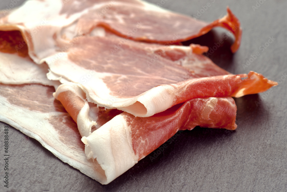 slices of Iberian ham, on stone base