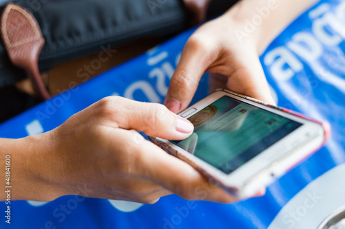 Girl finger touching screen on mobile phone