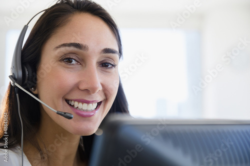 Caucasian businesswoman wearing headset at desk photo