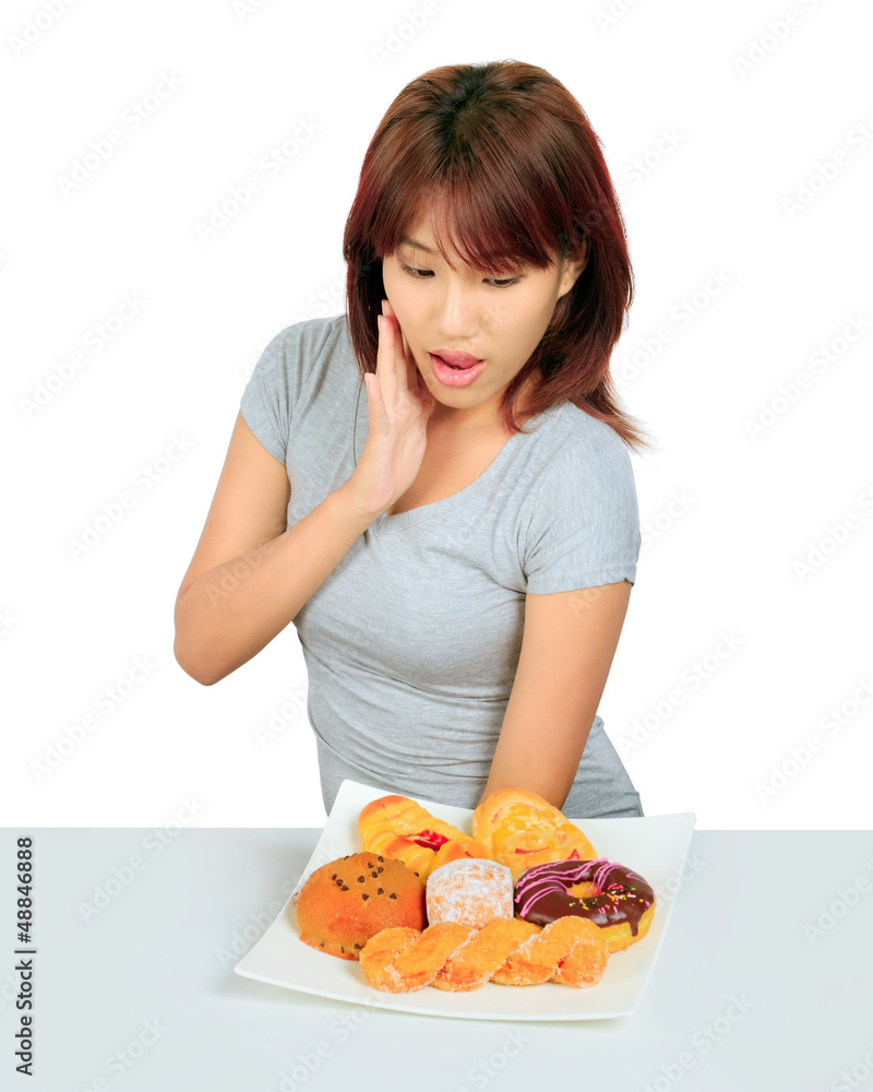 Isolated young asian woman with a donuts on the table Isolated young asian woman with a donuts on the table