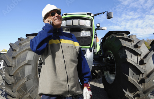 modern farmer with his giant tractor in the background photo