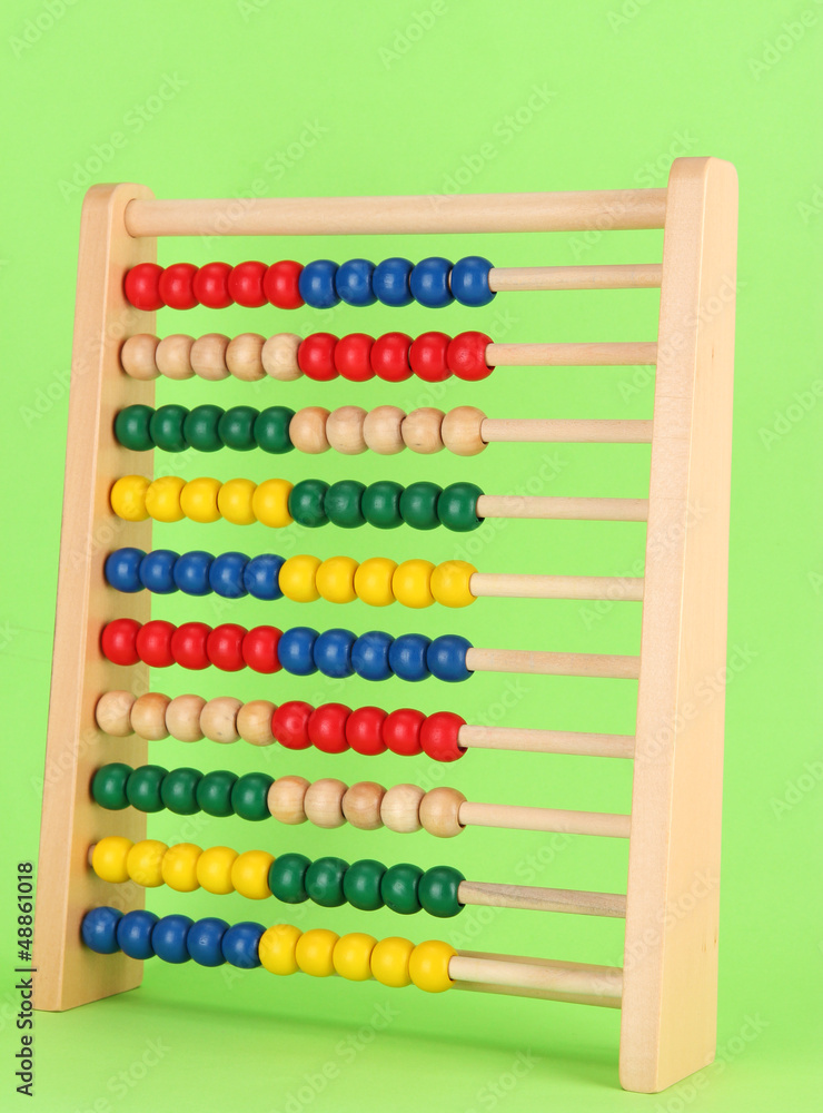 Bright wooden toy abacus, on green background Bright wooden toy abacus, on green background