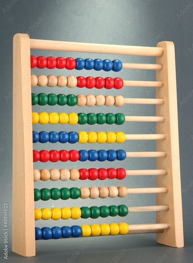 Bright wooden toy abacus, on grey background Bright wooden toy abacus, on grey background