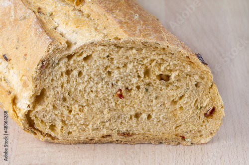 Loaf of mediterranean bread on wooden chopping board