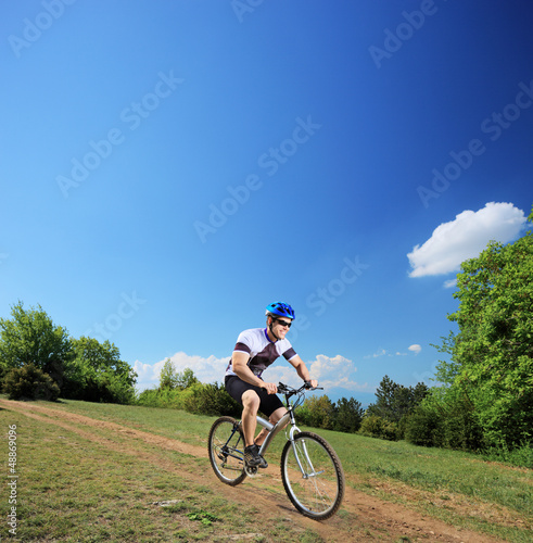 Male bicyclist riding a mountain bike downhill