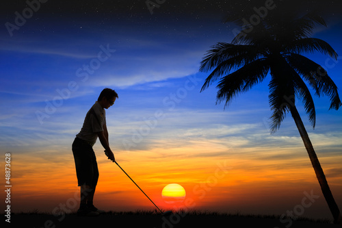 Silhouette golfer at sunset
