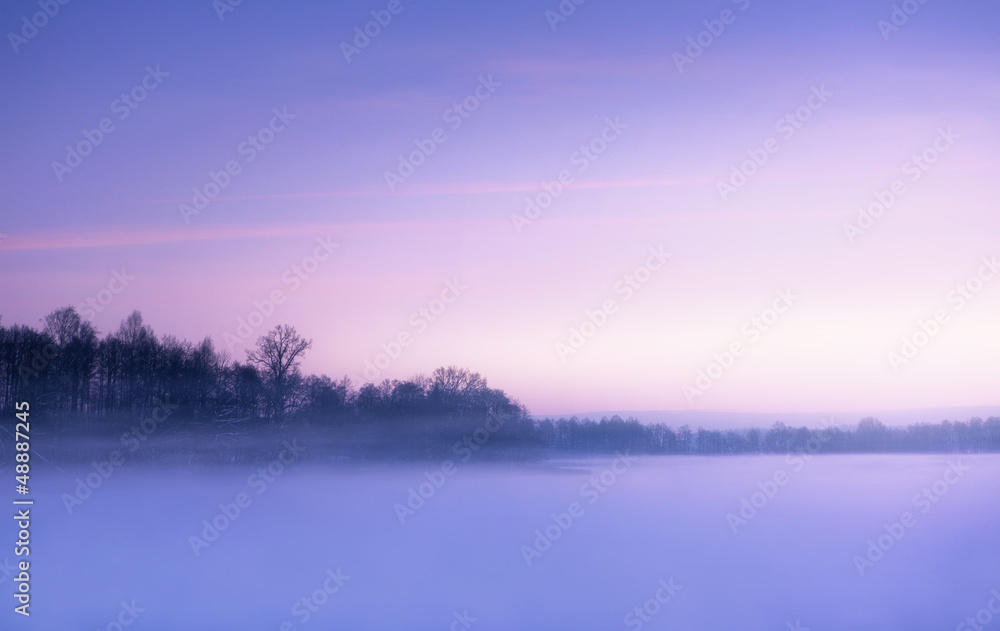 Winter landscape, foggy morning over frozen lake
