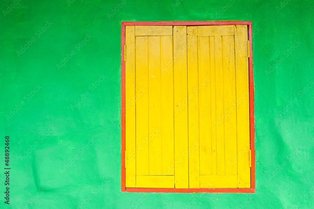 Yellow window on green wall