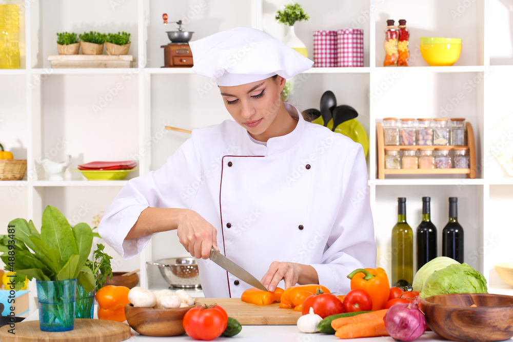 Young woman chef cooking in kitchen Young woman chef cooking in kitchen