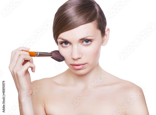 natural woman with cosmetic brush on cheek