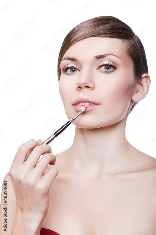woman with cosmetic brush on lips