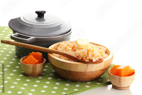 Taste rice porridge with pumpkin, isolated on white.