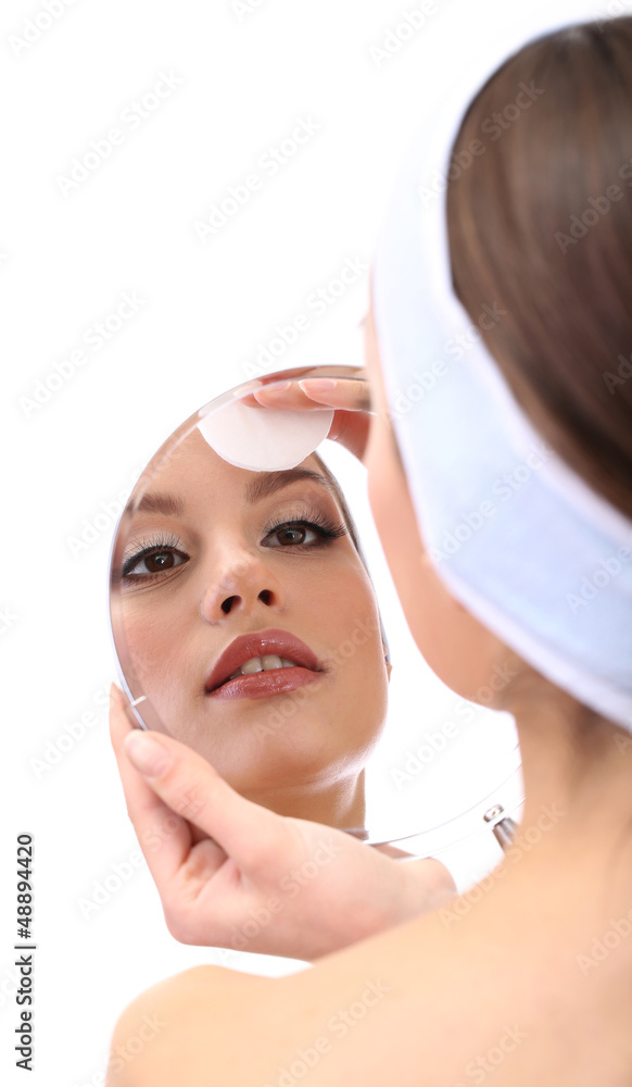 Young woman cleansing her face, isolated on white Young woman cleansing her face, isolated on white