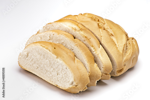 classic French loaf of bread, sliced​​, isolated on white