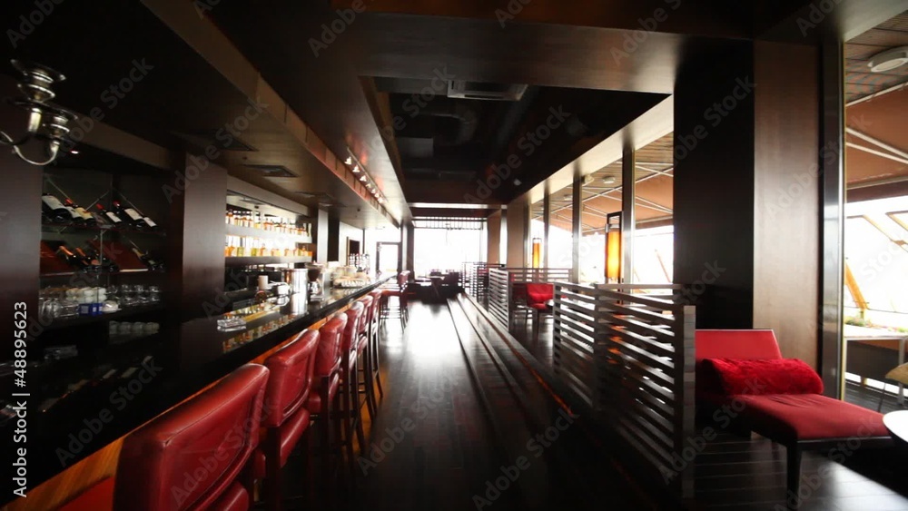 Chairs near to bar and little tables stand in long lounge Chairs near to bar and little tables stand in long lounge