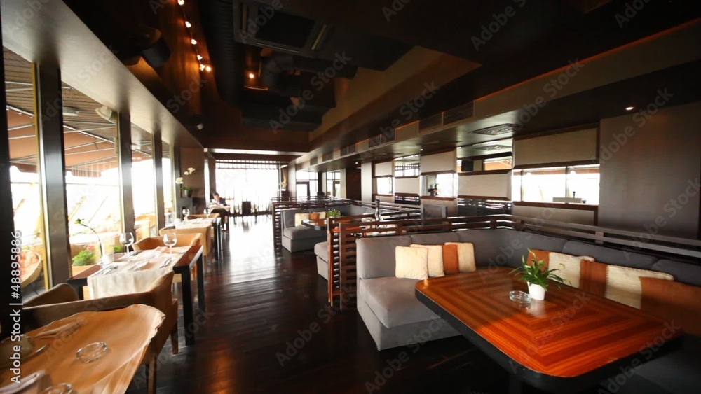 Man sits in restaurant lounge near to sofas and tables Man sits in restaurant lounge near to sofas and tables