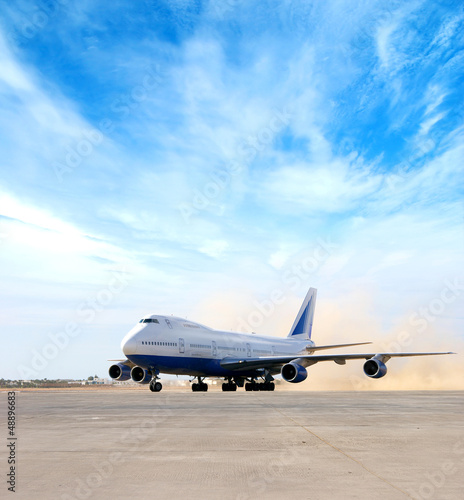 A large airplane on a blue sky and white clouds background