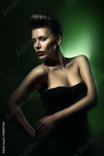 pretty beautiful woman with red lips in dark green light
