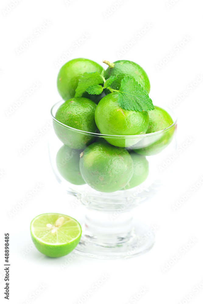 lime in a glass cup and mint isolated on white lime in a glass cup and mint isolated on white