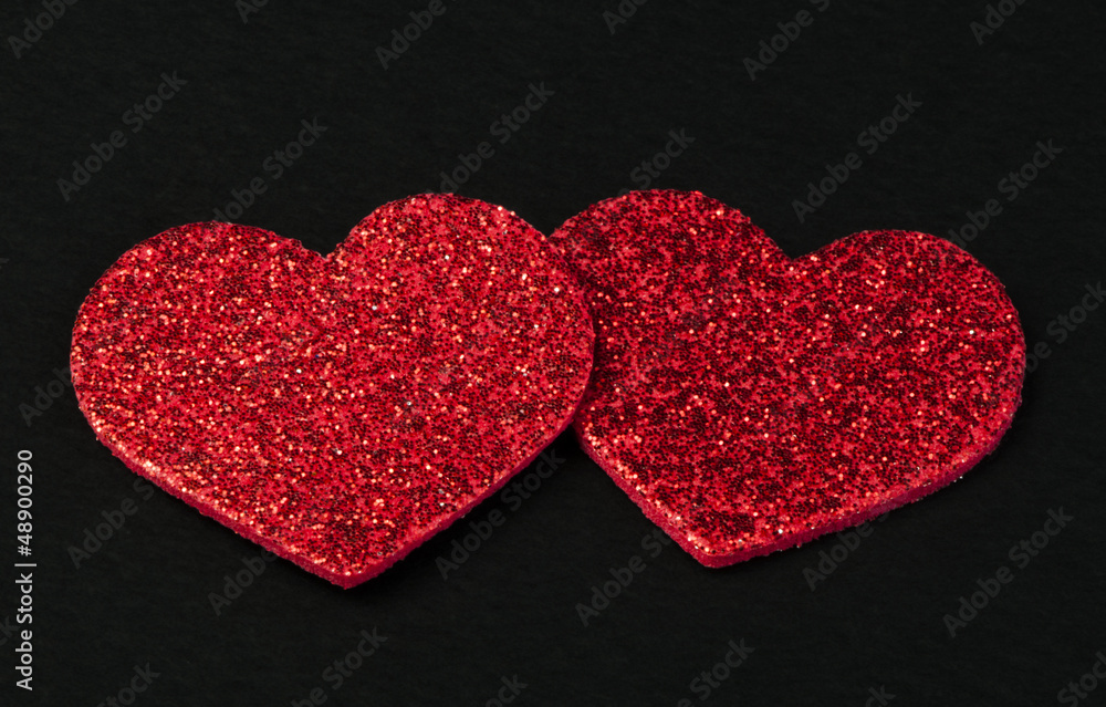Red shiny hearts on black background Red shiny hearts on black background
