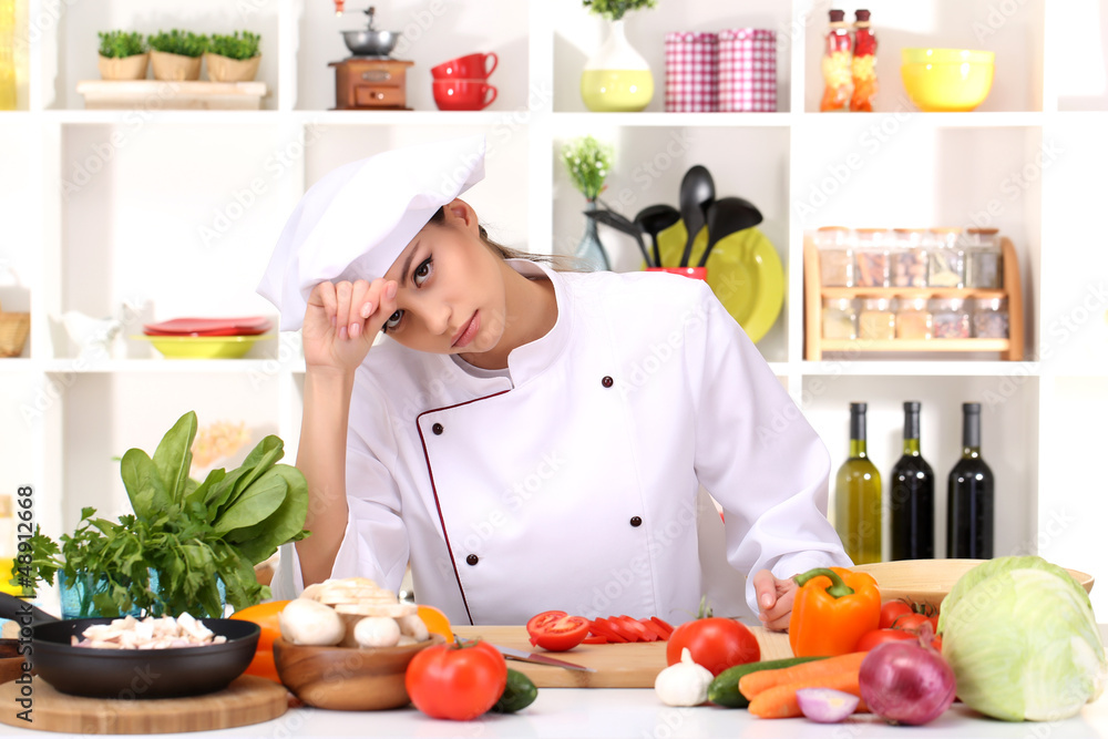 Young woman chef cooking in kitchen Young woman chef cooking in kitchen