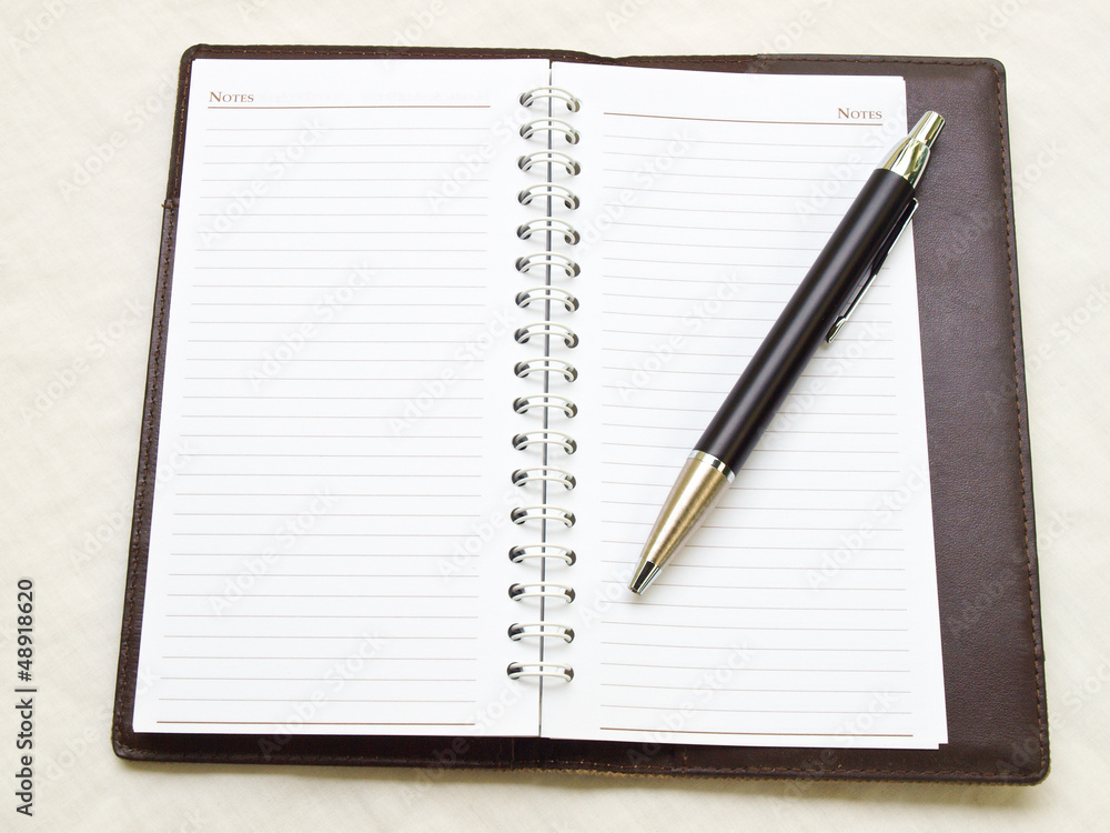 Opened pocket notebook and ballpen Opened pocket notebook and ballpen