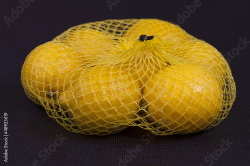 Lemons in a net isolated black background
