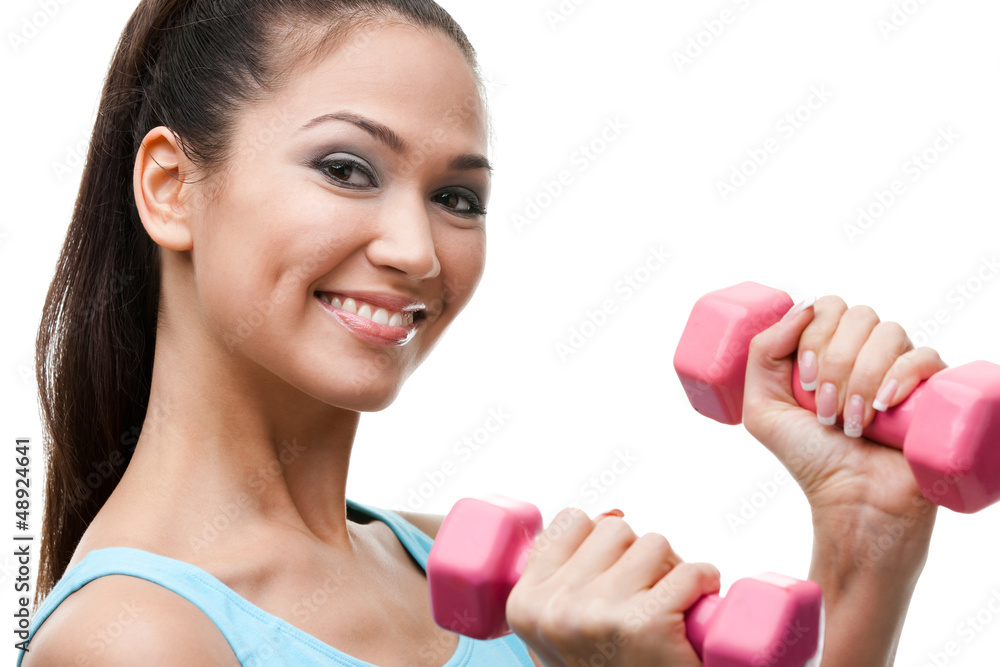Athletic young woman exercises with pink dumbbells Athletic young woman exercises with pink dumbbells