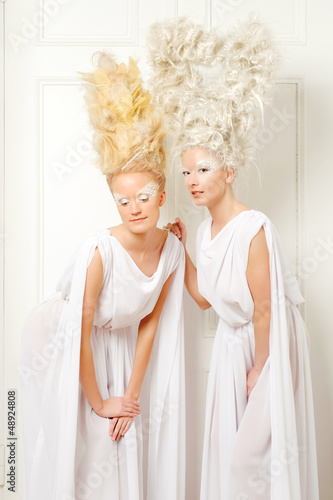 Two blonds with an tall artistic hairdo