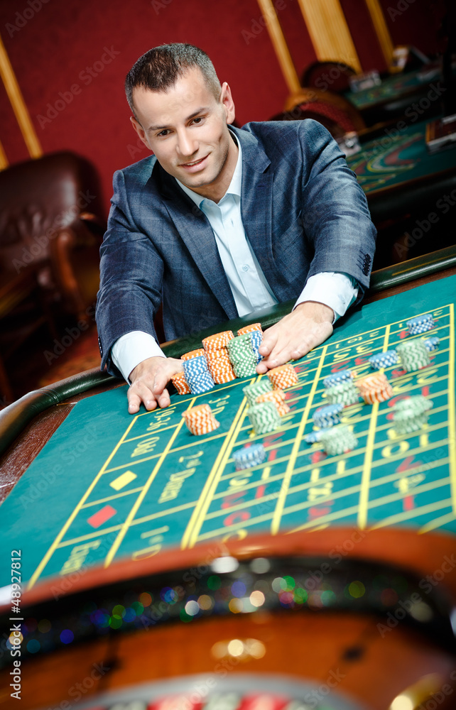 Smiley gambler stakes playing roulette at the casino Smiley gambler stakes playing roulette at the casino