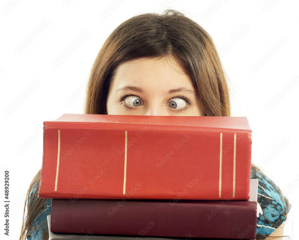 Female student with eyes crossed looking over stack of books Female student with eyes crossed looking over stack of books