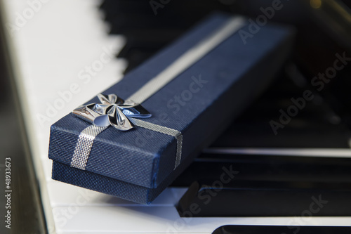 Foto caja de regalo junto a las teclas de un piano