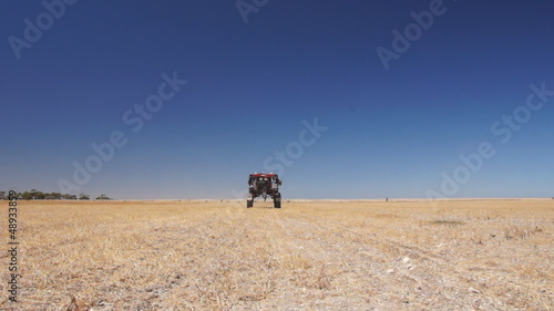 Agricultural spryer moving on farm field photo