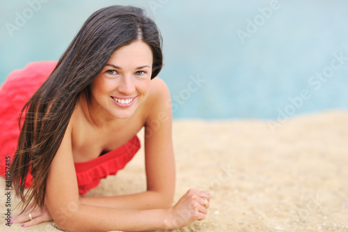 Beautiful girl lying on a beach and smiling