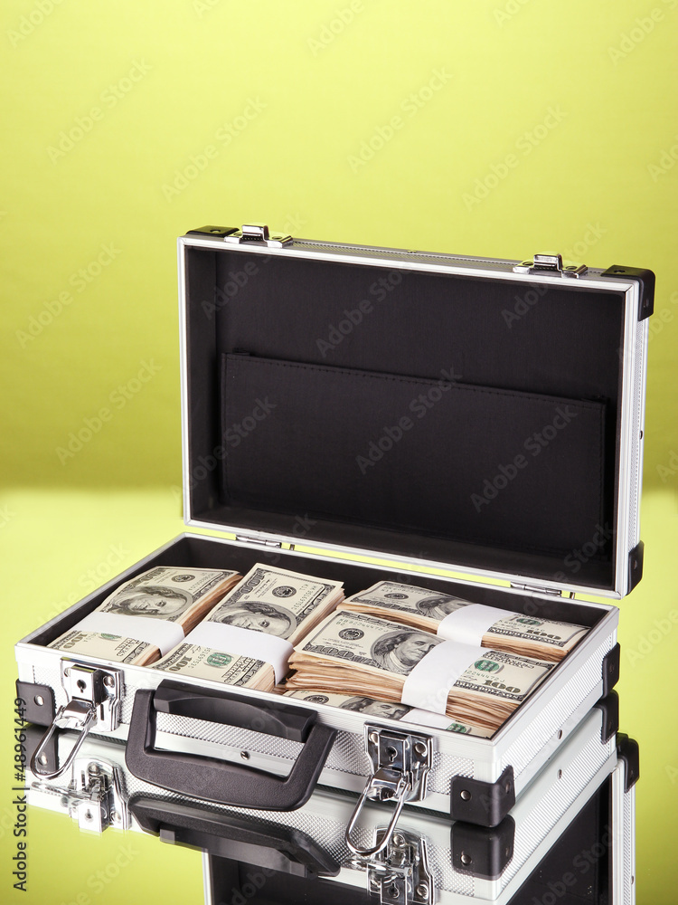 Suitcase with 100 dollar bills on green background Suitcase with 100 dollar bills on green background