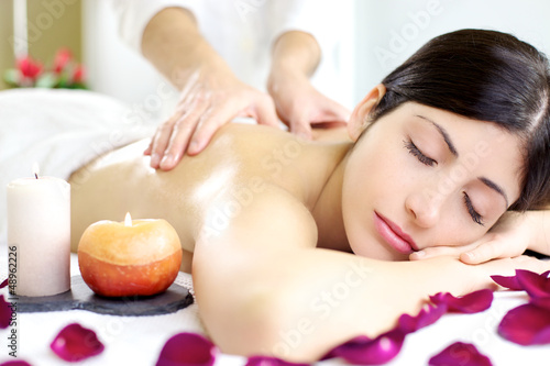 Happy relaxed woman getting back massage in luxury spa