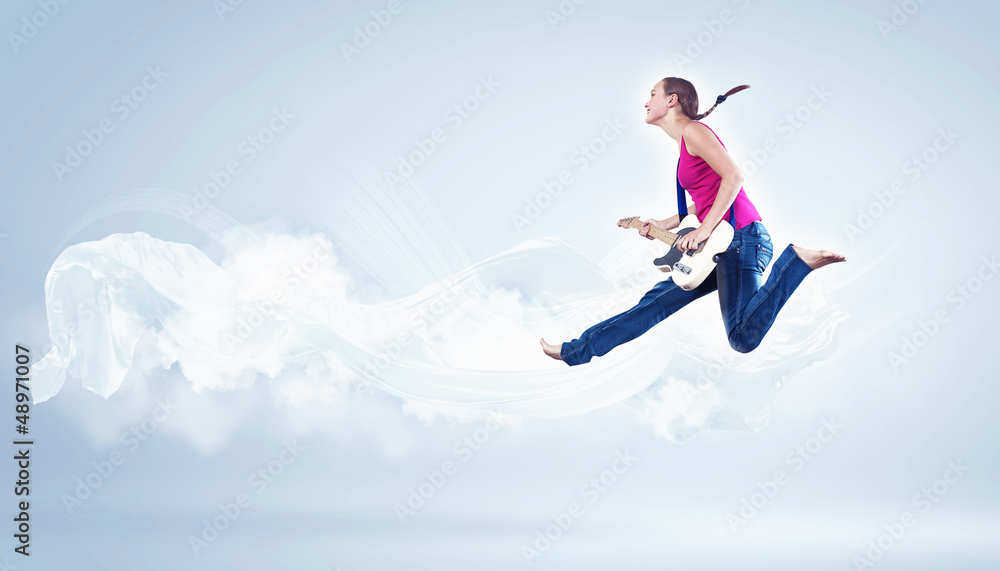 young woman playing on electro guitar and jumping young woman playing on electro guitar and jumping