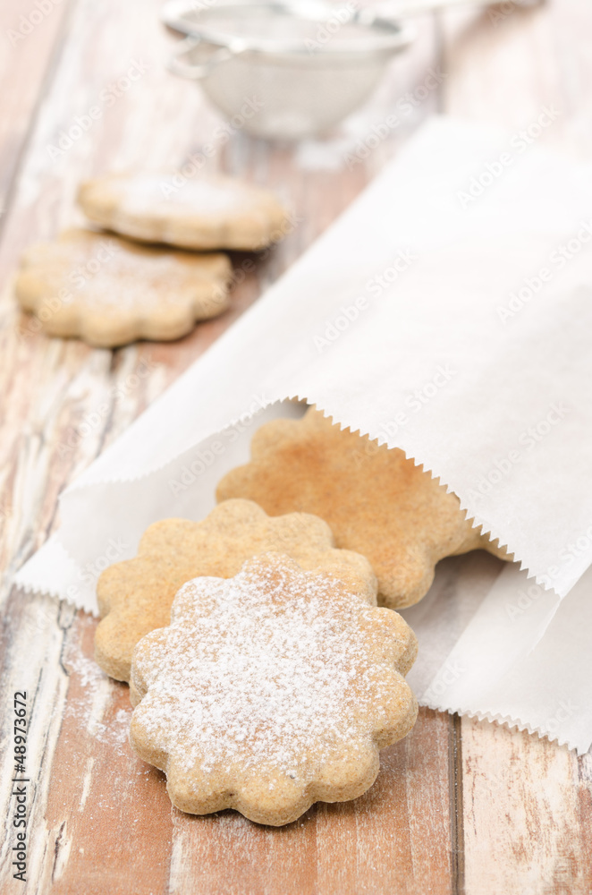 figured cookies sprinkled with powdered sugar in a paper bag figured cookies sprinkled with powdered sugar in a paper bag