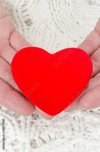 red heart in the hands of men