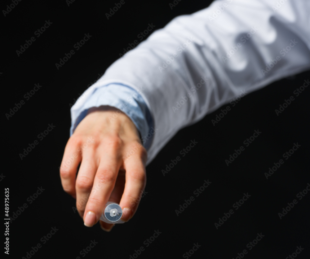 Fototapeta premium Closeup on hand with syringe isolated on black