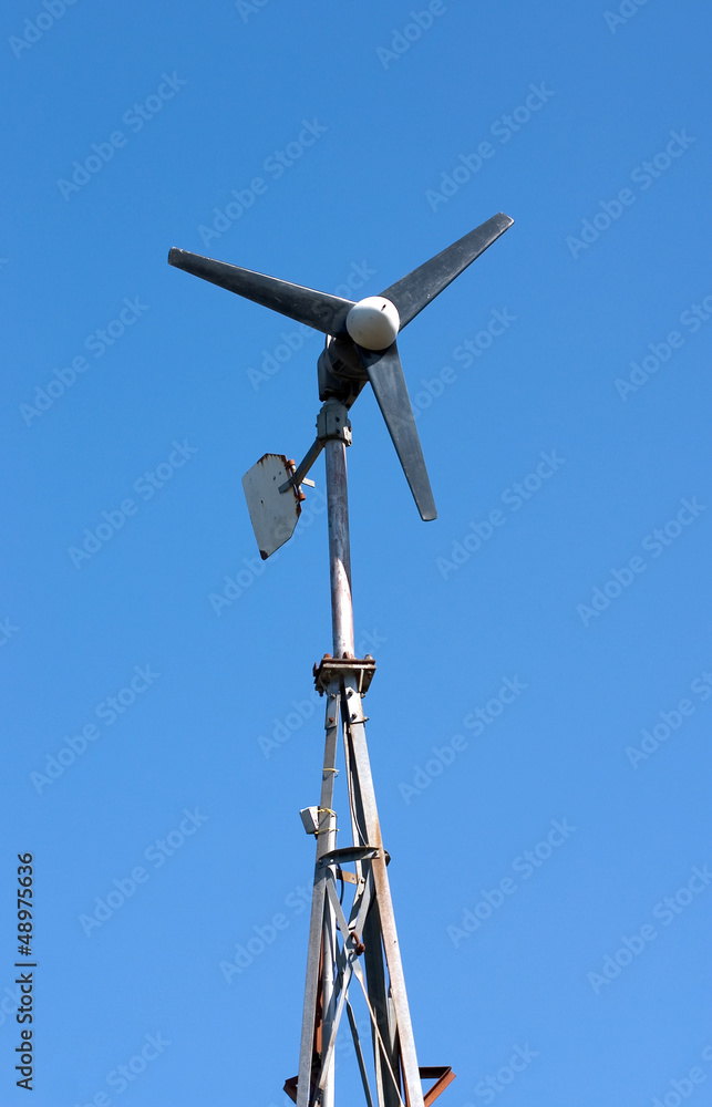 Small domestic wind turbine generator with a blue sky Small domestic wind turbine generator with a blue sky