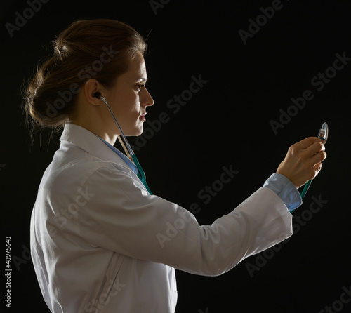 Silhouette of medical doctor woman using stethoscope