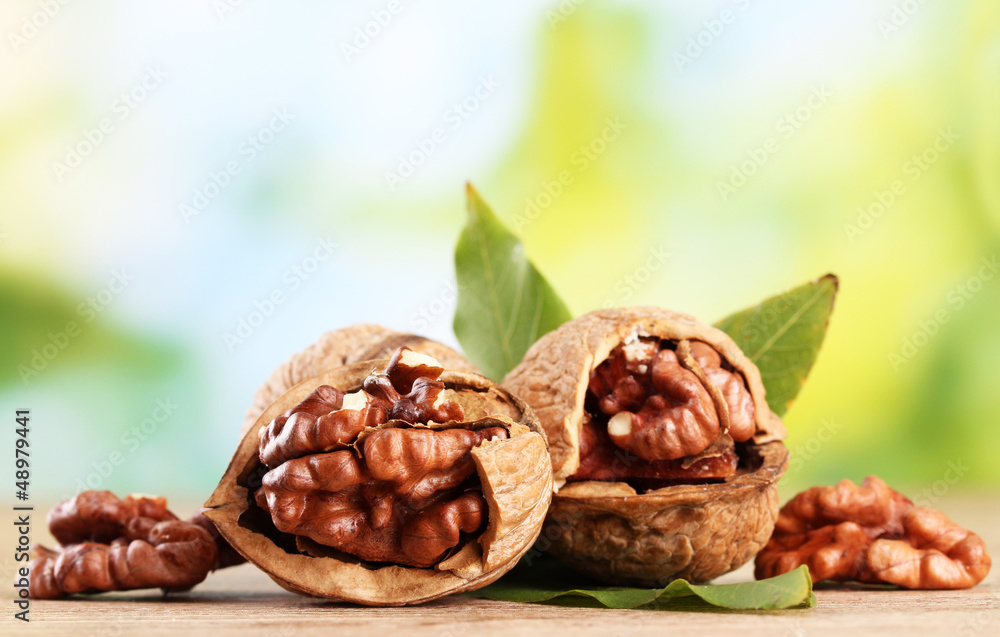 walnuts with green leaves, on green background walnuts with green leaves, on green background