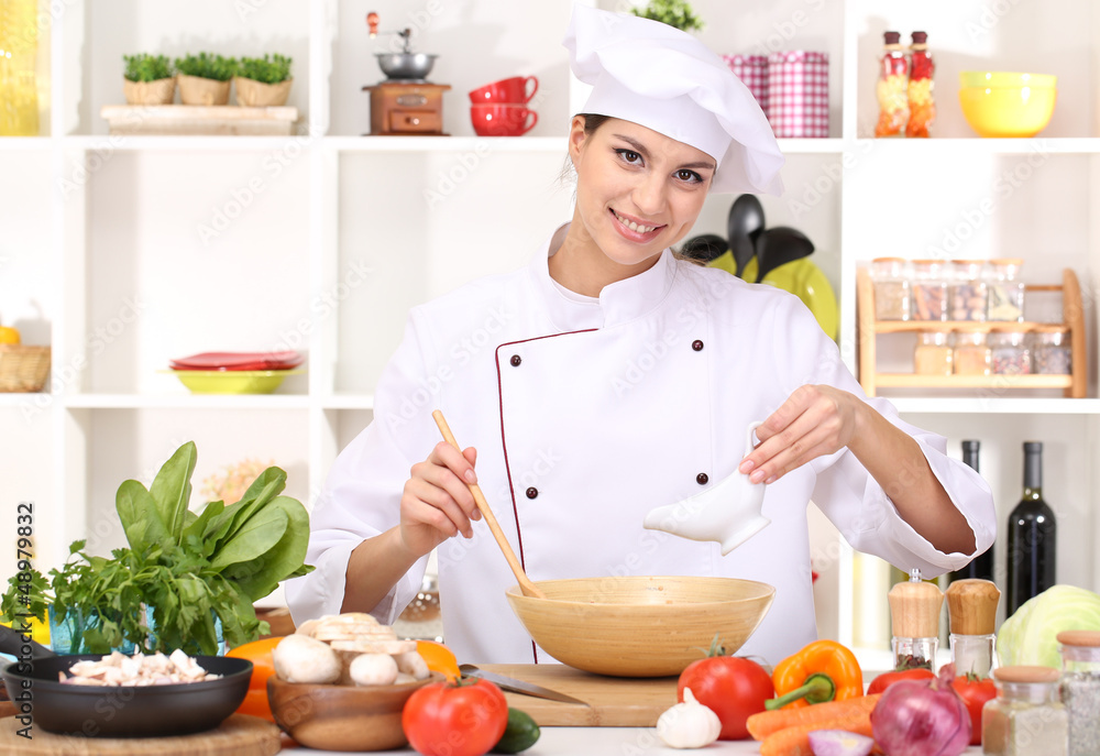 Young woman chef cooking in kitchen Young woman chef cooking in kitchen